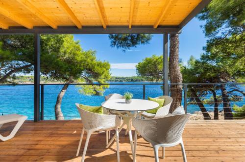 普拉Arena Stoja Camping Homes的露台设有一张桌子和椅子,位于水面甲板上