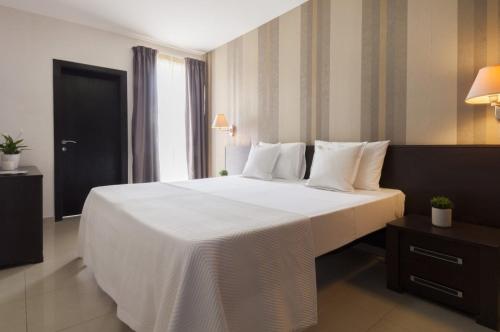 Il- GżiraValletta view Apartments by ST Hotels的一张大白色的床,位于酒店客房内