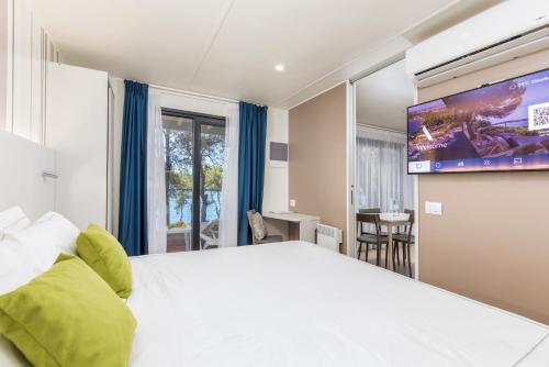 普拉Arena Stoja Camping Homes的一间酒店客房,配有一张大床和一台平面电视