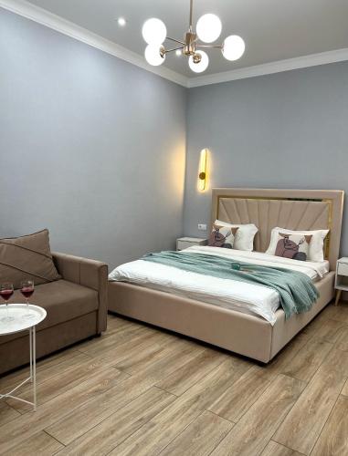 阿斯塔纳ЖК Champion с новым ремонтом的一间卧室配有一张床和一张沙发