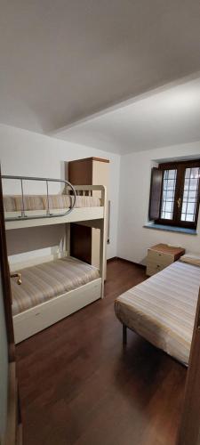 CaprieCasa del Rustico, Indipendente vista Sacra con dipinto的一间卧室配有两张双层床和一张床