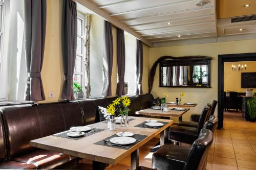 米尔滕贝格弗莱尔花园酒店的餐厅设有木桌和皮椅