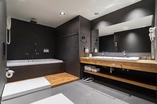 第比利斯第比利斯假日酒店 的浴室配有两个盥洗盆和浴缸。
