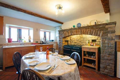 达尔文Midsummer Barn的一间带桌子和石头壁炉的用餐室