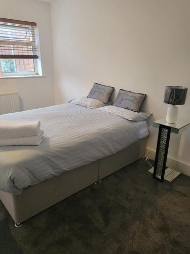 诺丁汉THE NEST的一间卧室配有一张带白色床单的大床和电视。