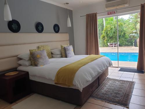 埃祖尔韦尼Damicha Boutique Lodge的一间卧室设有一张床和一个游泳池