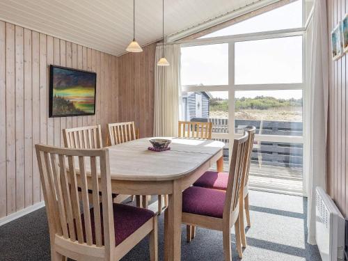 瓦伊厄斯斯特兰德6 person holiday home in Vejers Strand的一间带桌椅和窗户的用餐室