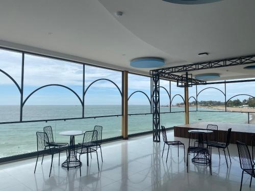 Tuy PhongKhách sạn - Nhà hàng Hoàng Phúc的配有桌椅的海景客房