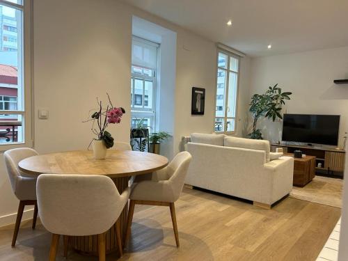 拉科鲁尼亚CoruñaFlat Apartamentos con encanto en el centro de A Coruña的客厅配有桌椅和电视。