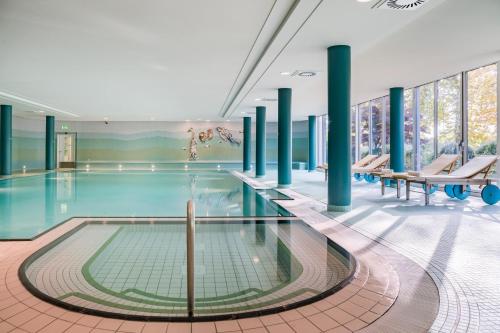 赖因斯贝格Seehotel Rheinsberg的一座建筑物内一座拥有蓝色柱子的游泳池
