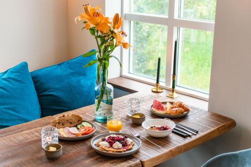 GodafossHótel Goðafoss Fosshóll的一张带早餐食品的桌子和花瓶