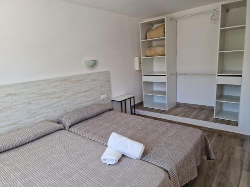 卡拉瓦德亚卡拉瓦德亚门公寓式酒店的一间卧室配有床和书架及面包
