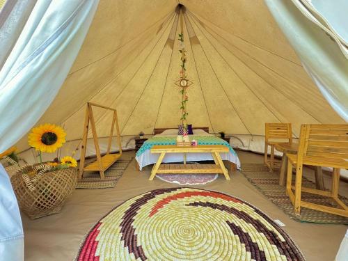 Tintipan IslandEl Cocotal Tintipán By Ashram的一间设有一张桌子和地毯的帐篷的房间