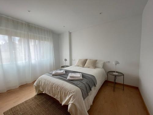 坎加斯德穆拉索Alojamiento céntrico en Cangas的白色的卧室设有床和窗户