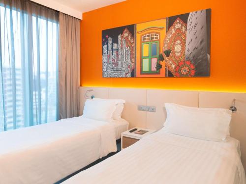 新加坡Mercure Singapore Bugis的橙色墙壁的客房内的两张床