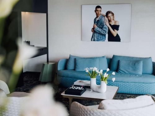 奥克兰SO/ Auckland的客厅配有蓝色的沙发和桌子
