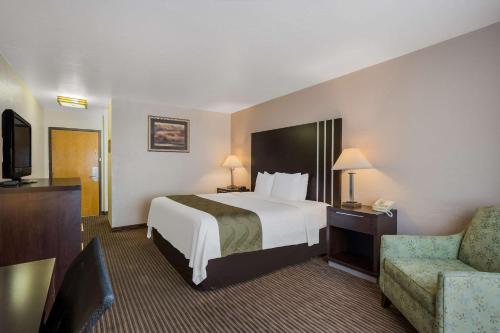 里奇菲尔德Quality Inn Richfield I-70的配有一张床和一把椅子的酒店客房