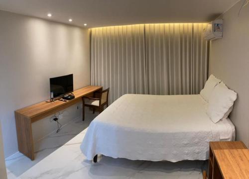 巴西利亚Flat Asa Norte CLN 311 by CentoEdez的一间卧室配有一张床和一张书桌及电视
