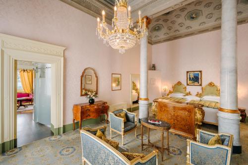贝拉吉奥Grand Hotel Villa Serbelloni - A Legendary Hotel的一间卧室配有一张大床和一个吊灯。