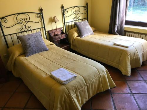 阿塞沃Casa Rural Los Robles的两张睡床彼此相邻,位于一个房间里