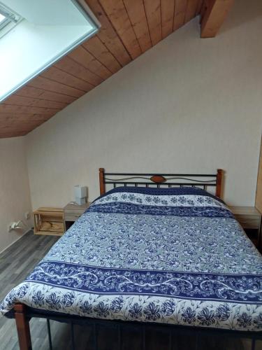 ManderfeldBaloe的一间卧室配有一张带蓝色和白色棉被的床