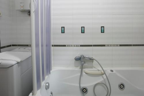 斯韦蒂·斯特凡Plava Vila Beach Apartments Sveti Stefan的带淋浴和浴缸的白色浴室