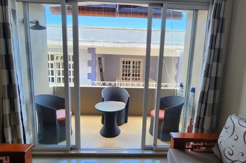 格兰贝伊Number 8, 2nd Floor, Pebble Bay Apartments的客房设有带椅子和桌子的阳台。