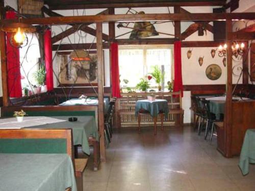 阿莫尔巴赫尊班德来耶尔旅馆的一间带桌椅和红色窗帘的餐厅