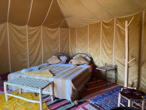 姆哈米德Authentique berber Camp的帐篷内一间卧室,配有一张床