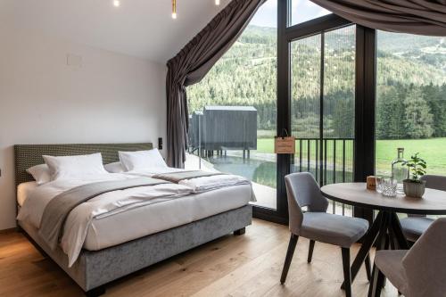 坎波图雷斯Såndgøld Alpine Glamping的一间卧室配有一张床、一张桌子和一个大窗户