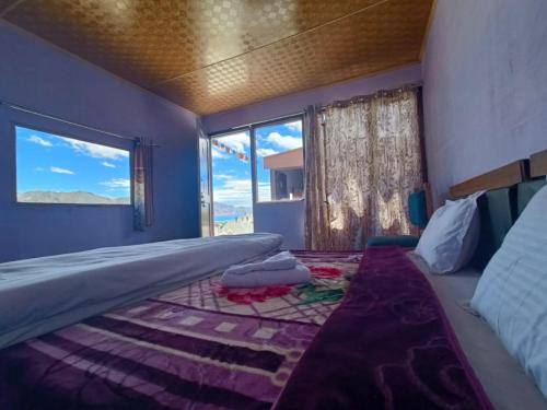 MerukNative Retreat Cottage , Pangong ladakh UT的一间卧室设有一张大床和大窗户