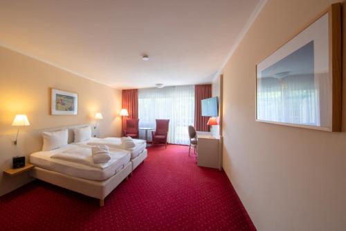 诺德奈诺德尼岛米歇尔斯汉希提克酒店的酒店客房,配有一张铺有红地毯的床
