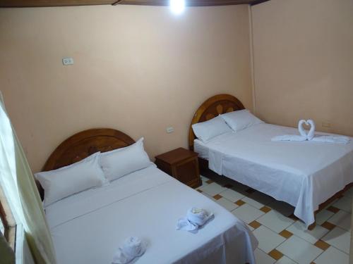 廷戈玛丽亚HOSTAL RESIDENCIAL UCAYALI的配有白色床单的客房内的两张床