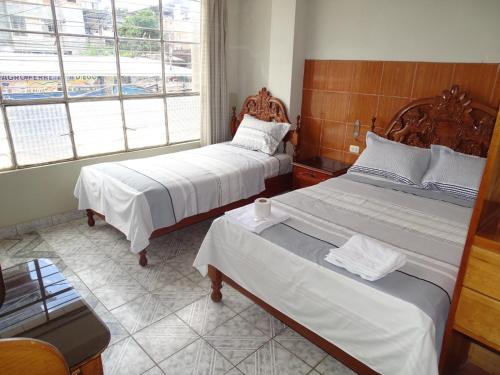 廷戈玛丽亚HOSTAL RESIDENCIAL UCAYALI的一间卧室设有两张床和窗户。