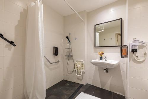 雷恩乐维多利亚餐厅酒店的带淋浴和盥洗盆的白色浴室