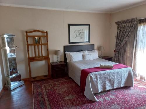 克拉伦斯Twogether House的一间卧室配有一张床和红色地毯