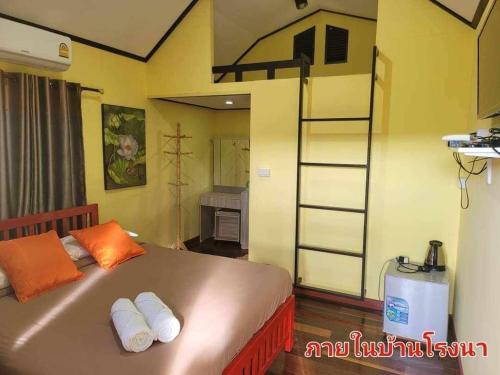 Ban Non Na YaoThe Memorize Resort的一间卧室配有一张带橙色枕头和梯子的床