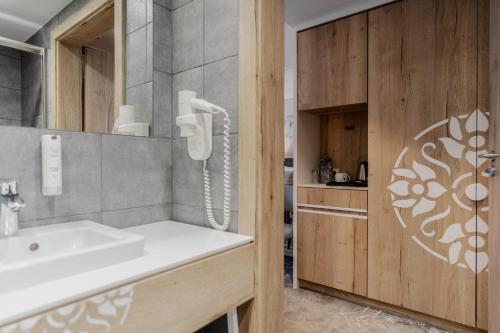 扎科帕内Hotel Aquarion Family & Friends - Destigo Hotels的一间带水槽的浴室和墙上的一部电话