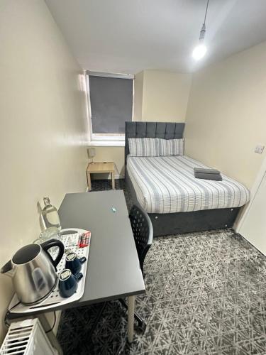 格拉斯哥Rangers GuestHouse的小房间设有桌子和床