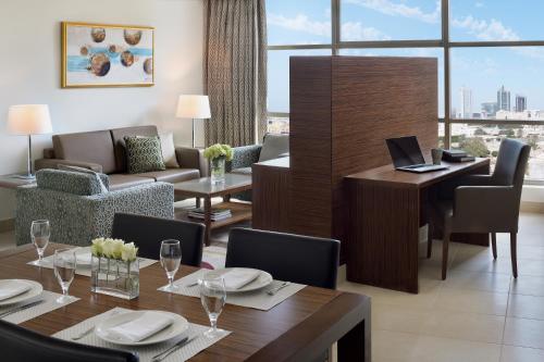 阿可贺巴Marriott Executive Apartments Al Khobar的用餐室配有带笔记本电脑的桌子