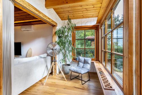 StarzachLa Casa Holzwiesen的客房设有床、风扇和椅子。