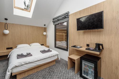 莫雷泰Molėtairesort的一间卧室配有一张床、一个壁炉和一台电视。