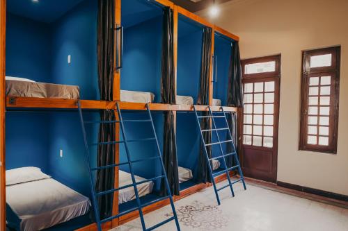 圣安娜-利弗拉门图Hostel Casarão Fronteira的蓝色墙壁的客房内的一组双层床