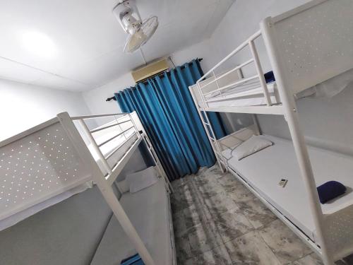 卡图纳耶克HOSTEL KATUNAYAKE At COLOMBO AIRPORT TRANSIT的客房设有两张双层床和蓝色窗帘