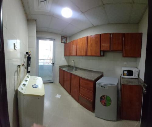 阿吉曼Al Khaleej Plaza Furnished Apartments LLC的厨房配有水槽、炉灶和冰箱