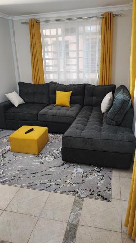 RuiruBliss Escapes的客厅配有黑色沙发和黄色枕头