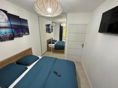 拜马欧LOCATION T2 MEUBLÉ BAIE MAHAULT CONVENANCE的一间卧室配有蓝色的床和镜子