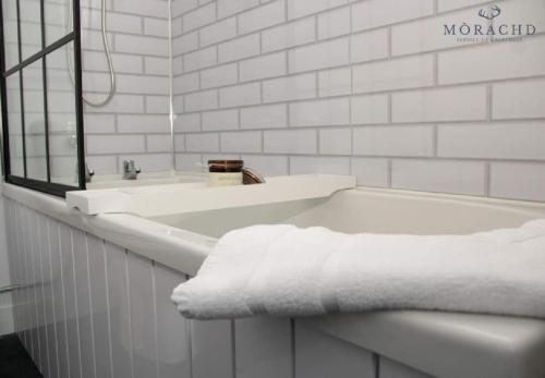 KinghornLinton的白色的浴室设有浴缸和水槽。