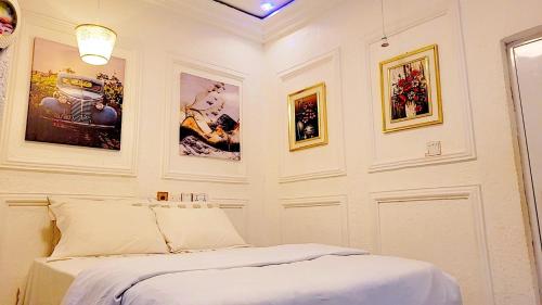 库马西Golden Aurora Lodge的卧室配有一张床,墙上挂有图片