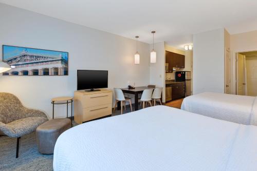 纳什维尔TownePlace Suites by Marriott Nashville Airport的酒店客房带两张床和一张桌子以及椅子。